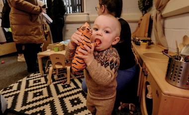 Little boy eating a plastic tiger